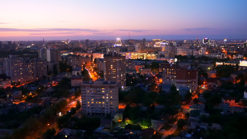 Evening cityscape after sunset. Modern city with buildings, roads and car traffic in twilight, view from rooftop. | Shutterstock HD Video #1031638577