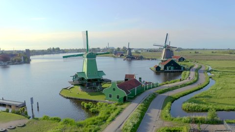 Moving past windmills, turning towards mills blades. Sustainable clean energy concept,great tourist attraction in Netherlands near Amsterdam. Aerial bird eye view of Zaanse Schans shot,drone footage