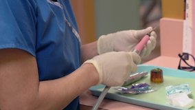 This close up video shows a dentist prepares dental tools and getting ready for an appointment with a patient.