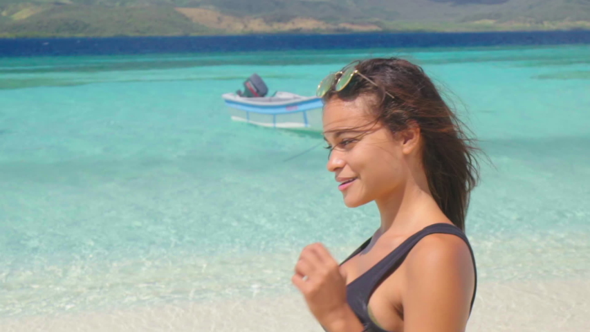 Slow Motion: Young Woman Walking Towards Clear, Blue Ocean with Boats Tethered - Cayo Arena, Dominican Republic