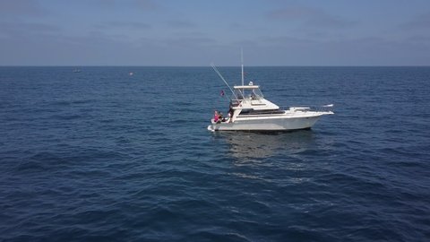 Aerial: Fishing Boat Sitting in the Ocean With People Hanging Out on Back - San Diego, California