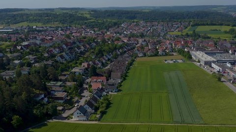 Aerial of Malmsheim, Germany in the foothills of the Black Forest.  Camera zooms in slowly over a large field toward town.