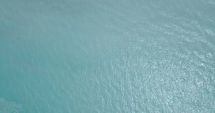 NATURE 4K Beach aerial top down view of ocean surface to white sandy beach and vegetation with a twisty dirt road