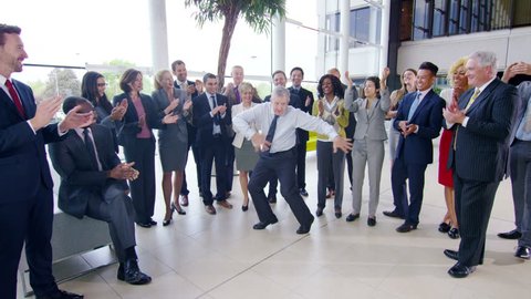 4K Self confident businessman doing funny dancing to entertain his colleagues