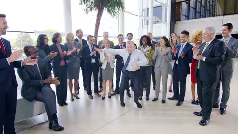4K Self confident businessman doing funny dancing to entertain his colleagues