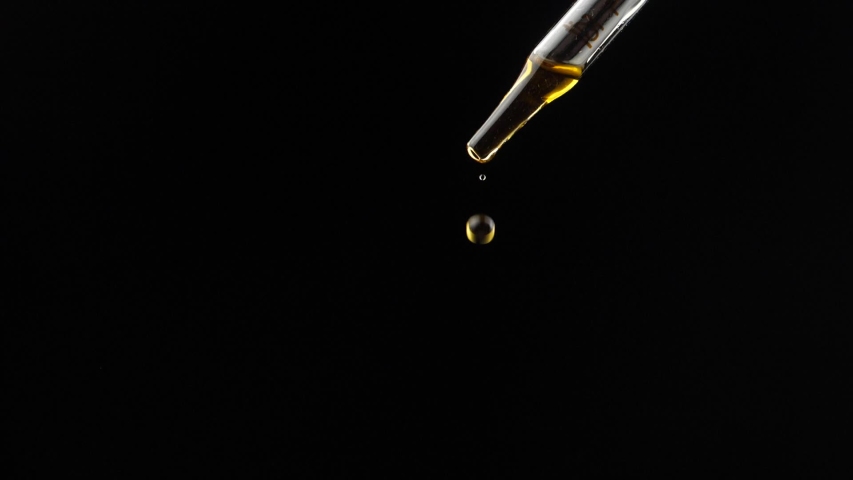 Close-up of lavender oil drops falling from the pipette, on the white background. The pipette is held vertically. | Shutterstock HD Video #1031677469