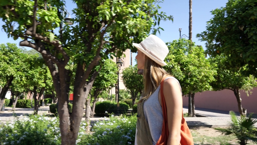 Smiling woman walking through Koutoubia gardens, Marrakech