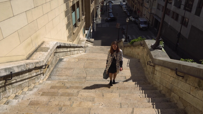 A girl walks through the old streets of Paris.