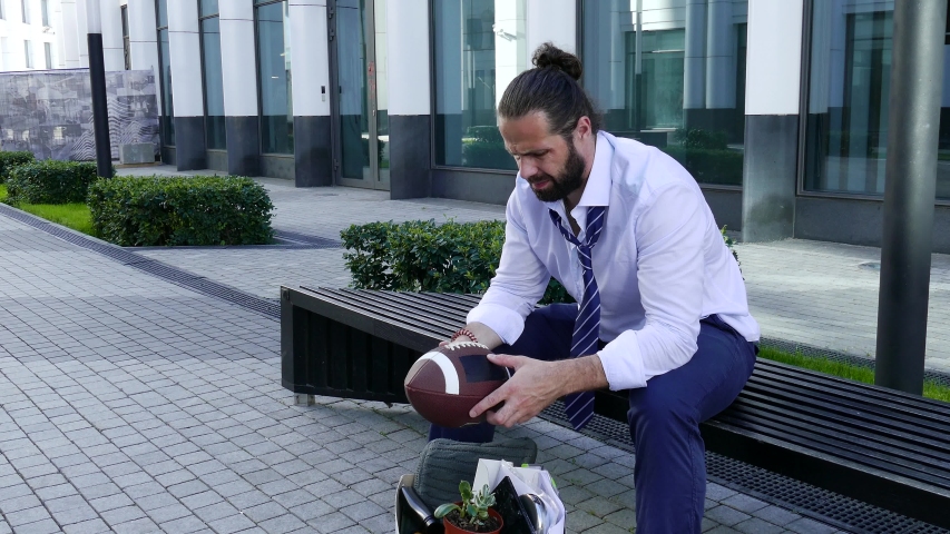 Fired manager goes through the items in the box outdoors.