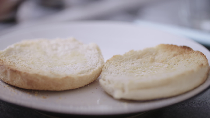 Chef buttering perfectly baked english muffin in preparation for breakfast Royalty-Free Stock Footage #1031688893