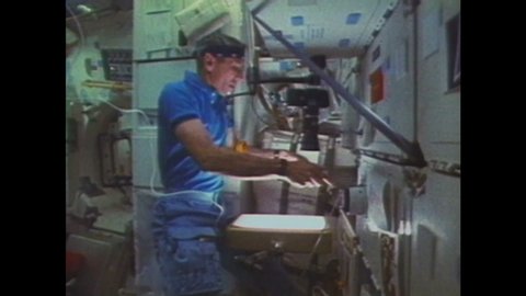 1980s: UNITED STATES: astronaut works with protein crystal growth in microgravity environment. Astronaut mixes ingredients in space lab.