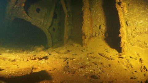 Diving inside shipwreck in underwater submarine world of ships from World War II as result of military battles on Truk Islands. Concept of diving in historic underwater sites of sunken wreck.