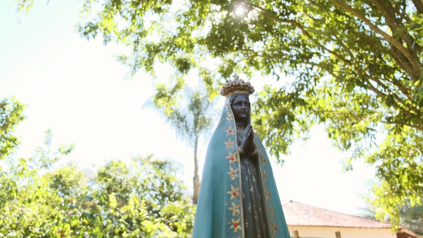 Sculpture of the image of "Nossa Senhora Aparecida" the patroness of Brazil. Image with gimbal on nature background on sunny day.