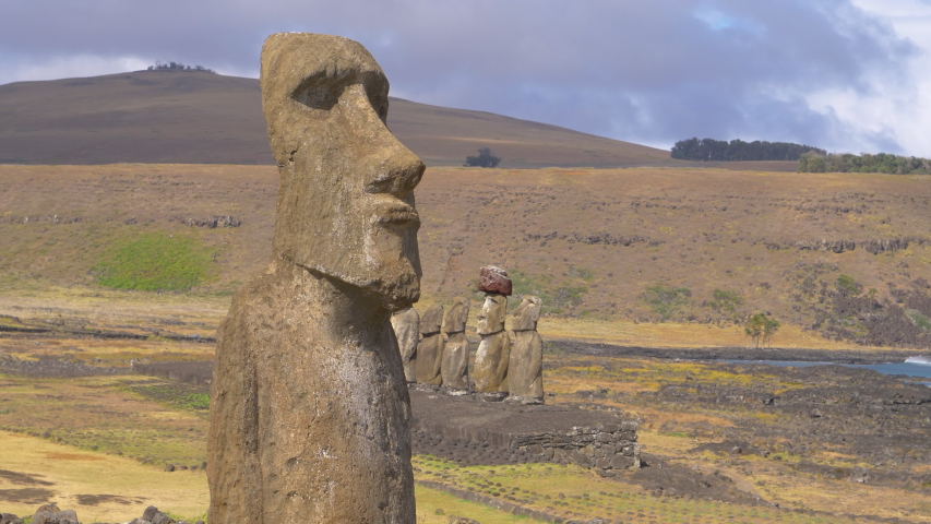 DRONE COPY SPACE: Stunning shot of a mysterious ancient monoliths shaped as humans. Flying around a legendary moai statue on a remote island in Chile. Scenic national park full of intriguing megaliths