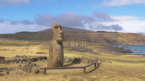 AERIAL, COPY SPACE: Flying around a large moai sculpture on a remote island in sunny Chile. Spectacular view of the untouched Easter Island with its world famous volcanic human shaped sculptures.