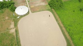 View from above, aerial video shooting, training sand field, playground, riders, jockeys ride horses, perform various exercises with horses, next to barriers. summer, outdoors