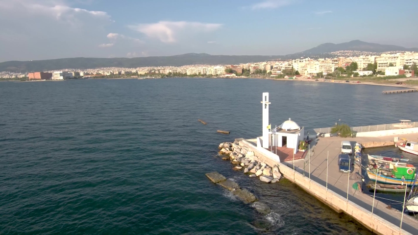 Aerial view of small white Greek Orthodox church at the edge of the marina for boats in Kalamaria Thessaloniki Greece,move forward by drone