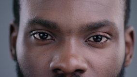 Close-up view of afro-american man eyes blinking and looking straight. Detailed portrait of confident and calm black guy staring at camera. - Powered by Shutterstock - Get 15% off with code: PIKWIZARD15