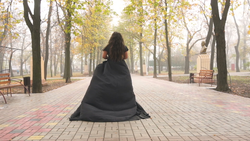 Beautiful plus size model in black long amazing dress at the park. Alternative beauty. Fashion Royalty-Free Stock Footage #1031741258