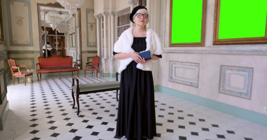 Portrait of old woman in stylish clothes in museum. Green screen, slow motion, chromakey