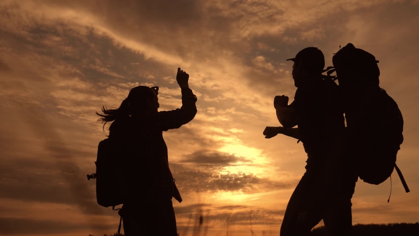 Teamwork business journey concept win. couple man and woman jump joy hold hand silhouette. slow motion video. teamwork couple husband and lifestyle wife hikers sunshine sunset tourists go on a nature | Shutterstock HD Video #1031745596