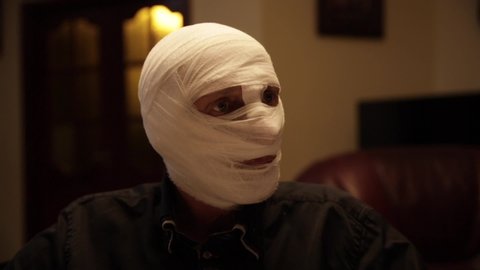 A man who changed his the appearance with a bandage on his head. Looks like  a mummy or zombie 