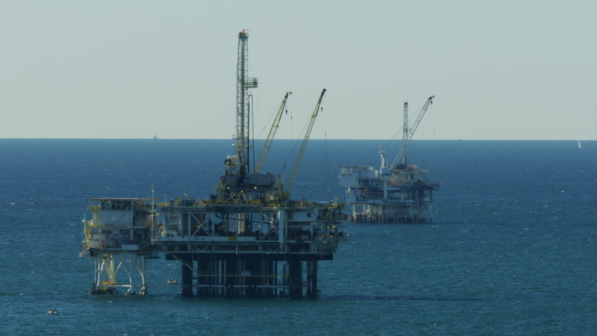 Aerial view of off shore Industrial Oil Rig production drilling platforms extracting petroleum from the Pacific ocean California USA RED WEAPON