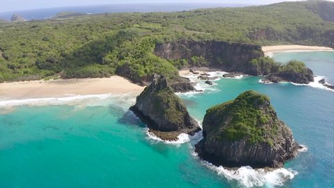 Beautiful aerial video of the hill two brothers in fernando de noronha brazil with blue sea, sand, sky, sun and clouds