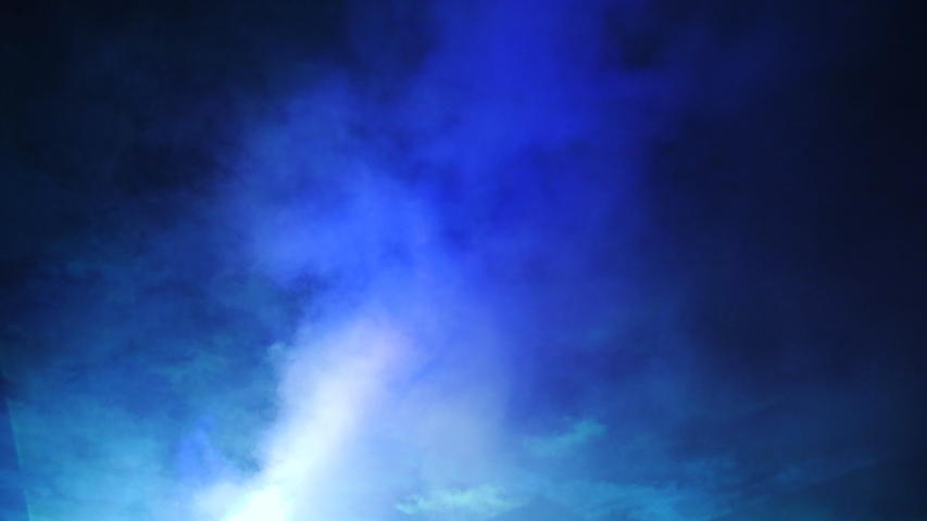 Laser show in a nightclub under the open sky. Laser beams and strobe lights in the night sky.