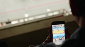Sport fans make video of competitions  with smartphone. Unrecogizable people.