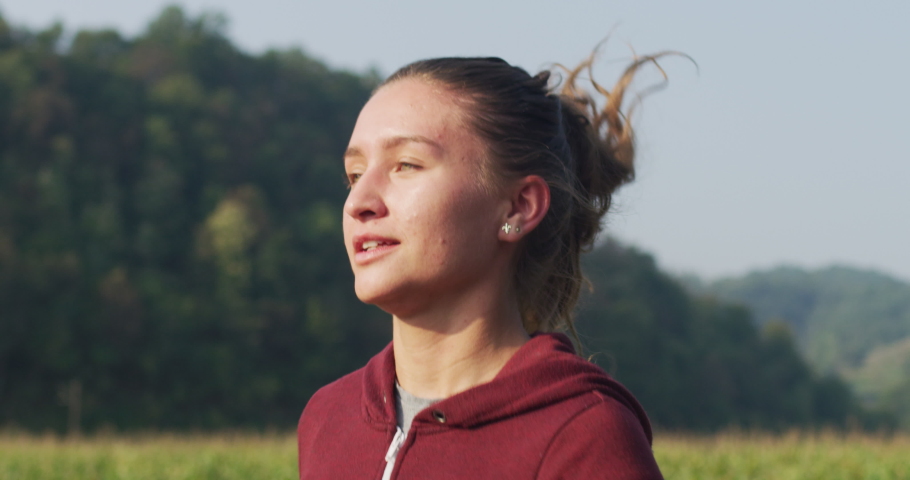 Woman runner running through the spring park road