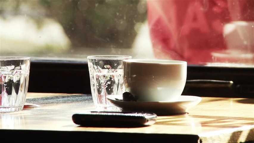 Cup of Coffee and Cell Phone on Wooden Table by Window in Cafe, Buenos Aires, Argentina