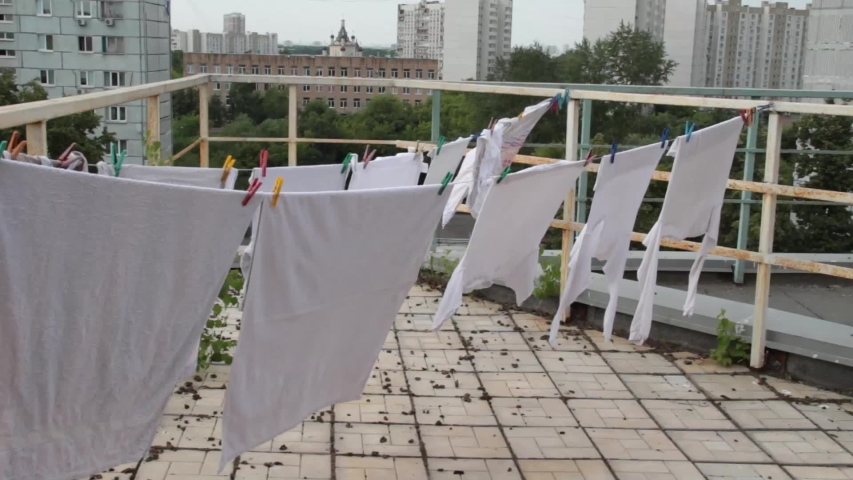 White linen dries on a rope on the roof.