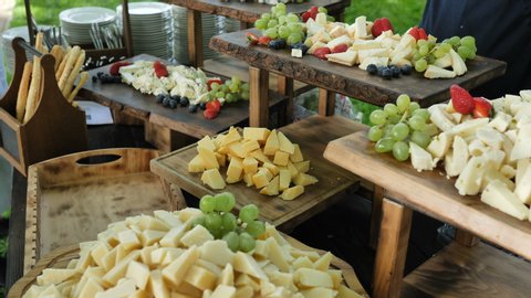 Catering service. Station with a large assorted cheese Cheddar, Gorgonzola, Brie, Gouda cheese, Parmesan, Feta, Ricotta, Maasdam, Emmental and Gruye. Decorated with Grapes, Strawberries, Nuts, Cashew