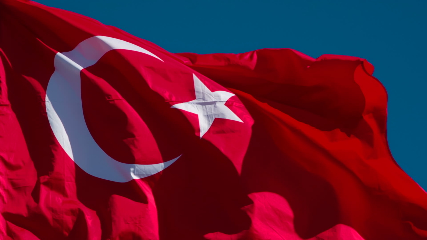Turkish Flag Wiggles the Wind. The Big State Flag is illuminated by the sun and flutters epically in the wind against the blue sky. Slow Motion 240 fps