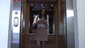 Young businesswoman using her phone while getting into an elevator. - Powered by Shutterstock - Get 15% off with code: PIKWIZARD15