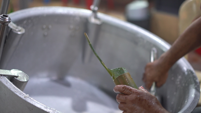 Worker is seen inserting a rice on the bamboo during cooking a lemang, a traditional Malaysian food