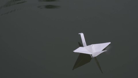 Closeup of origami swan floating on water surface
