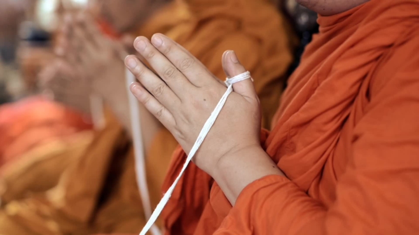 holy thread holding by buddhist monk while praying in religious ceremony