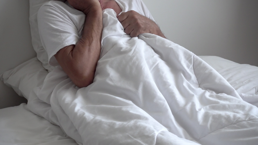 Senior elderly man sitting on bed with depressed after waking up in morning; tilt up Royalty-Free Stock Footage #1031817161