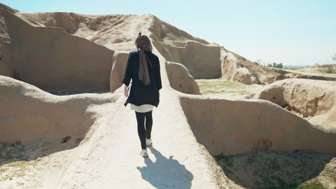 Women walking alongside a archeological sight in Iran.