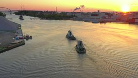 Two tugboats going to work in early morning light, sunrise, aerial drone view.
