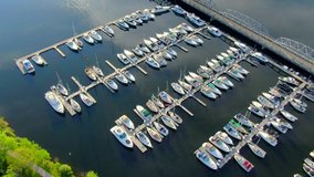 Docks, luxury yachts, sailboats, scenic bridge, aerial view.
