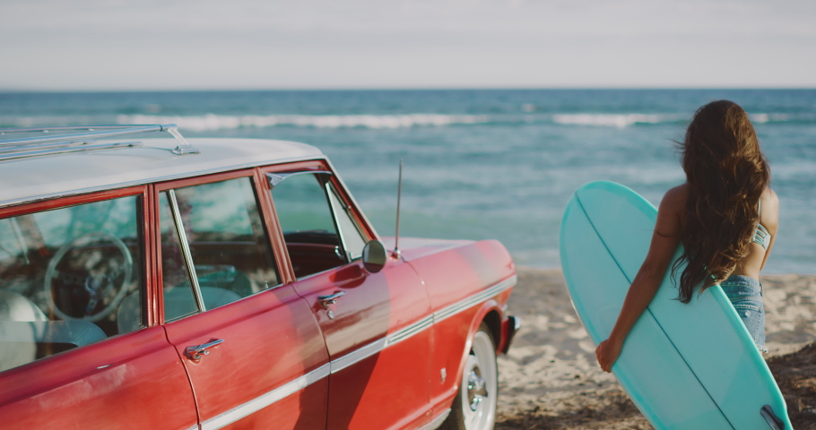 Young attractive women at the beach with vintage beach cruiser car, getting ready to surf at sunset, island beach lifestyle | Shutterstock HD Video #1031878346