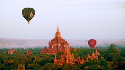 BAGAN, MYANMAR - DEC 21, 2014: Hot air balloons flying at sunrise over ancient Buddhist Temples at Bagan. Myanmar (Burma) travel landscape and destinations