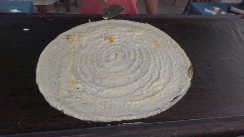 Slow motion preparation of paneer Masala dosa, a popular South Indian food. It is made from rice, lentils, cheese, potato, methi, and curry leaves, served with chutneys and sambar. stabilized 4k 