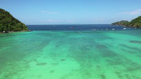 Aerial view of long-tail boat at sea, view from above. Aerial video of Long tail Boat floating in a turquoise blue and green sea water. 
Tropical landscape Phi Phi Island, Andaman Sea, Krabi, Thailand