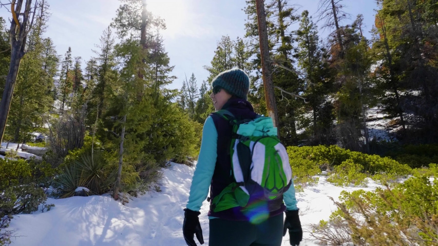 Girl woman hiking with red rocks formation and snow near Bryce Canyon in southern Utah.