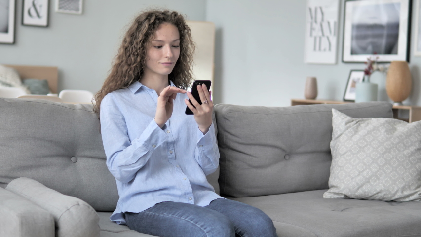 Relaxing Young Curly Hair Woman Using Smartphone | Shutterstock HD Video #1031918126