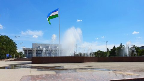 June 2019, Uzbekistan, Tashkent. Palace "Friendship of Peoples" - the main concert hall of Uzbekistan. Next to the square in Tashkent is a 65-meter-high flagpole on which the Uzbekistan flag flies.